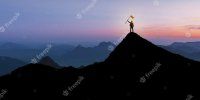 silhouette-businessman-standing-mountain-top-sunset-twilight-background-with-flag-winner-succe...jpg